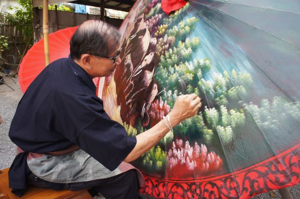old man painting color on umbrella in Umbrella festival at Borsang village