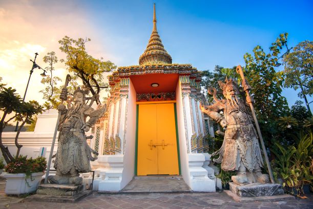 Guardian statues stand guard at a gate of Wat Pho (Pho Temple) in Bangkok, Thailand