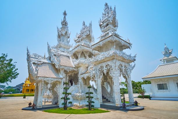 The richly decorated shrine in garden of White Temple (Wat Rong Khun), Chiang Rai, Thailand