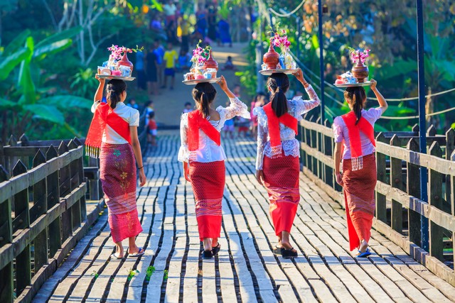 Beautiful Mon girl walk in wooden mon bridge, longest wooden bridge in Mon village, Sangklaburi