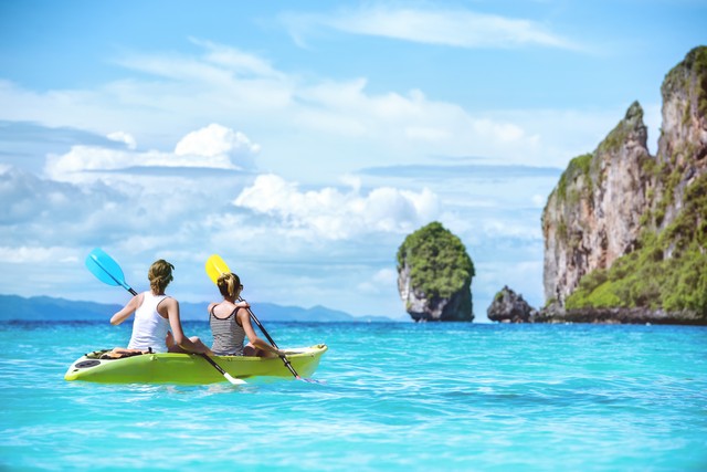 Two ladies are kayaking or kanoeing at beautuful tropical lagoon at Phi-Phi islands